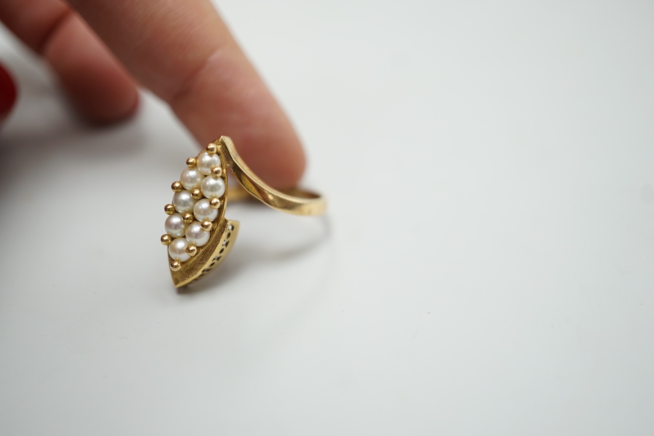 A modern continental yellow metal and seed pearl cluster set marquise shaped ring, size N
